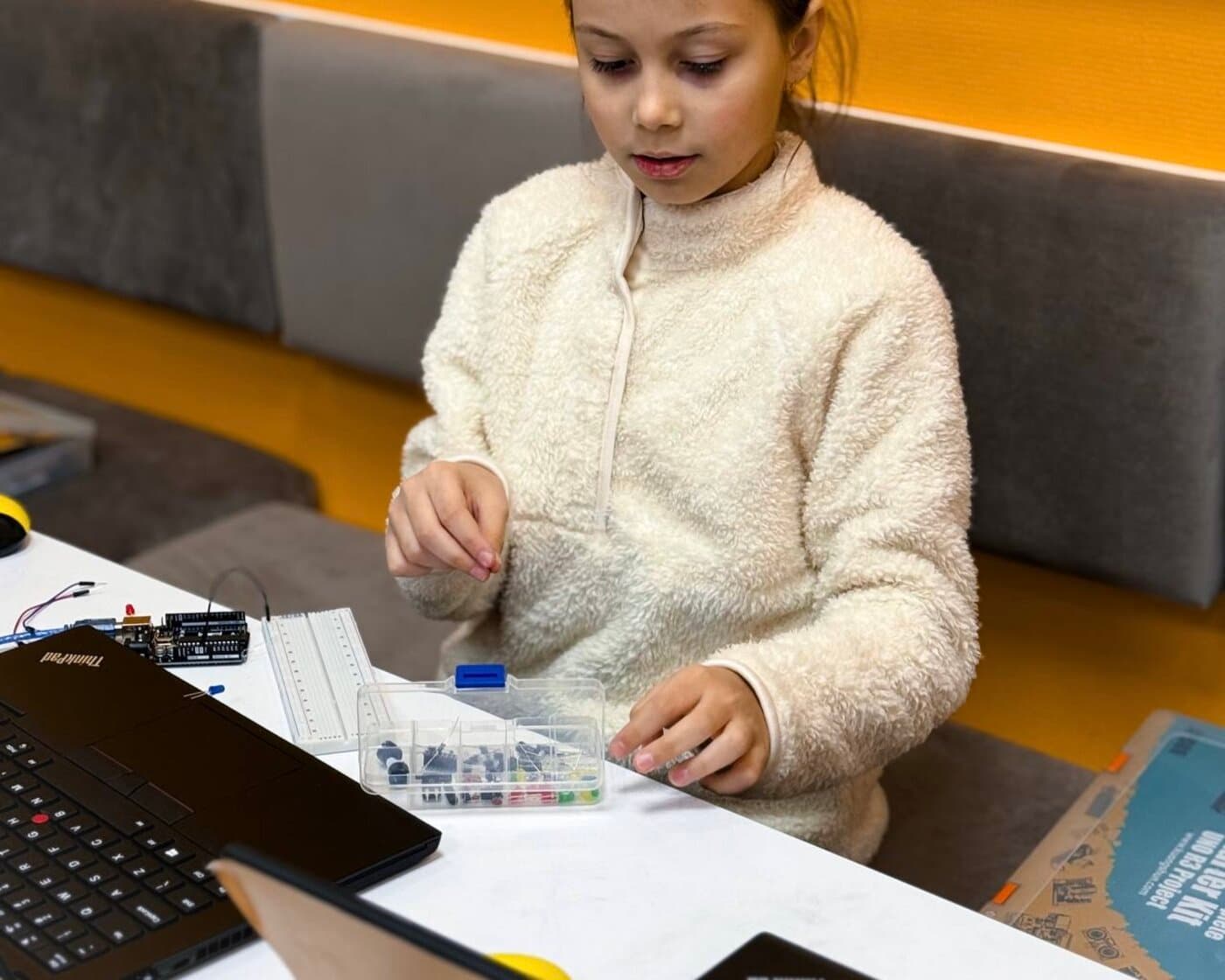 Copil lucrând cu kit Arduino